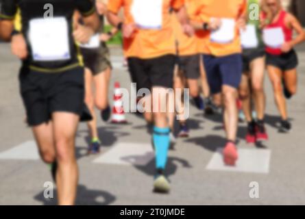 intenzionalmente fuori fuoco molti corridori durante la gara su strada in città, ideale come sfondo di sport Foto Stock