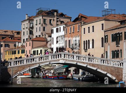 Scene di Venezia, Italia il 6 ottobre 2023. I turisti attraversano un ponte su un canale. Foto Stock