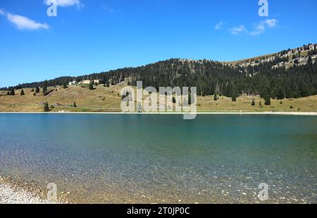 montagne e lago artificiale utilizzati come serbatoio d'acqua per la neve artificiale sulle piste da sci in inverno Foto Stock