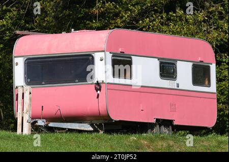 Caravan rosa d'epoca in campeggio. Molto insolito e divertente. Foto Stock