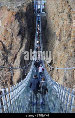 Hir, Ardabil, Iran. 5 ottobre 2023. Il popolo iraniano cammina lungo il ponte sospeso in vetro ad arco nell'area ricreativa di Hir vicino alla città di Ardabil. Con i suoi 208 metri di lunghezza, 1,5 metri di larghezza e 100 metri di altezza, il ponte è un luogo frequentato dai turisti. (Immagine di credito: © Rouzbeh Fouladi/ZUMA Press Wire) SOLO USO EDITORIALE! Non per USO commerciale! Foto Stock