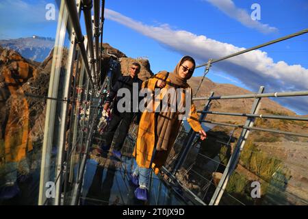 Hir, Ardabil, Iran. 5 ottobre 2023. Una donna iraniana cammina lungo il ponte sospeso in vetro ad arco nell'area ricreativa di Hir vicino alla città di Ardabil. Con i suoi 208 metri di lunghezza, 1,5 metri di larghezza e 100 metri di altezza, il ponte è un luogo frequentato dai turisti. (Immagine di credito: © Rouzbeh Fouladi/ZUMA Press Wire) SOLO USO EDITORIALE! Non per USO commerciale! Foto Stock