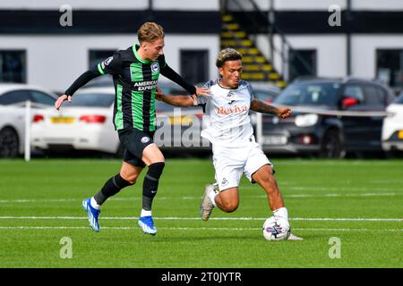 Swansea, Galles. 7 ottobre 2023. Zane Myers di Swansea City tiene fuori la sfida di Casper Nilsson di Brighton & Hove Albion durante la partita di Premier League Cup tra Swansea City Under 21 e Brighton & Hove Albion Under 21 alla Swansea City Academy di Swansea, Galles, Regno Unito il 7 ottobre 2023. Crediti: Duncan Thomas/Majestic Media/Alamy Live News. Foto Stock