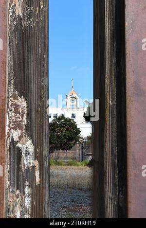 SANTA ANA, CALIFORNIA - 2 ottobre 2023: La torre dell'orologio dello Spurgeon Building vista attraverso una recinzione all'interno del Distretto degli artisti. Foto Stock