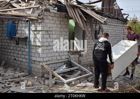 I residenti locali tolgono i loro effetti personali da una casa privata che è stata pesantemente danneggiata dai bombardamenti russi nel villaggio di Bilenke nella regione di Zaporizhzhia. Intorno alle 08:00 di sabato 7 ottobre 2023, le forze russe hanno bombardato il villaggio di Bilenke nella regione di Zaporizhzhia. Circa cinque case private sono state danneggiate a causa dell'attacco. I russi bombardano regolarmente le aree popolate nella regione di Zaporizhzhia. Non solo le città e i villaggi in prima linea, ma anche la città stessa di Zaporizhzhia sono cadute sotto il fuoco nemico. Foto Stock