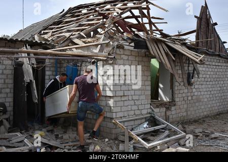 I residenti locali tolgono i loro effetti personali da una casa privata che è stata pesantemente danneggiata dai bombardamenti russi nel villaggio di Bilenke nella regione di Zaporizhzhia. Intorno alle 08:00 di sabato 7 ottobre 2023, le forze russe hanno bombardato il villaggio di Bilenke nella regione di Zaporizhzhia. Circa cinque case private sono state danneggiate a causa dell'attacco. I russi bombardano regolarmente le aree popolate nella regione di Zaporizhzhia. Non solo le città e i villaggi in prima linea, ma anche la città stessa di Zaporizhzhia sono cadute sotto il fuoco nemico. Foto Stock