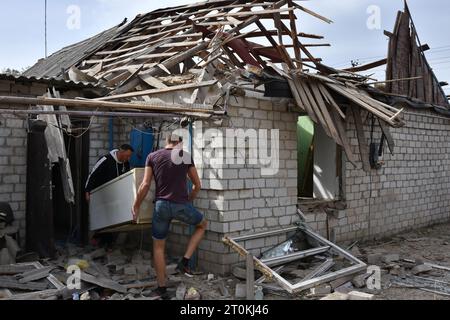 I residenti locali tolgono i loro effetti personali da una casa privata che è stata pesantemente danneggiata dai bombardamenti russi nel villaggio di Bilenke nella regione di Zaporizhzhia. Intorno alle 08:00 di sabato 7 ottobre 2023, le forze russe hanno bombardato il villaggio di Bilenke nella regione di Zaporizhzhia. Circa cinque case private sono state danneggiate a causa dell'attacco. I russi bombardano regolarmente le aree popolate nella regione di Zaporizhzhia. Non solo le città e i villaggi in prima linea, ma anche la città stessa di Zaporizhzhia sono cadute sotto il fuoco nemico. (Foto di Andriy Andriyenko/SOPA Images/Sipa USA) Foto Stock