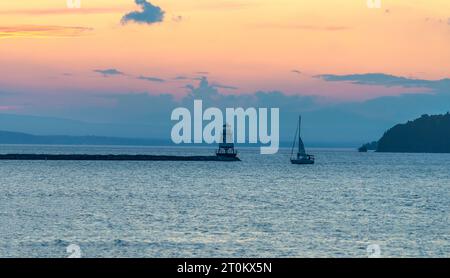 Vista del faro nord, del frangiflutti e della barca a vela sul lago Champlain al crepuscolo, avvicinandosi a Burlington, Vermont. Foto Stock