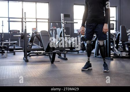 foto ritagliata di un giovane con gambe artificiali in piedi in palestra. sicurezza. motivazione, forza di volontà, spazio copioso Foto Stock