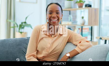 Sorriso, donna nera e ritratto sul divano in casa come proprietario di una casa, investitore immobiliare o acquirente di mutui ipotecari. Giovane, felice o africano Foto Stock