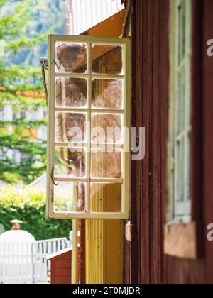 Finestra norvegese in legno, aperta, soleggiata, atmosfera serena, niente persone. Foto Stock