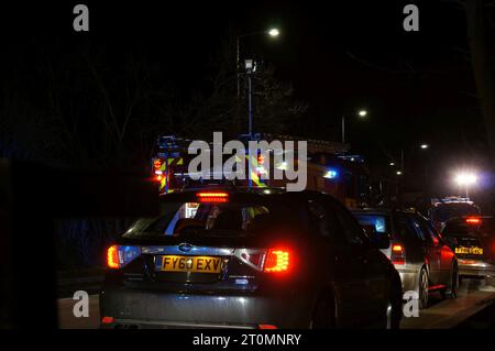 traffico che passa di notte con luci lampeggianti provenienti da veicoli di emergenza. Foto Stock