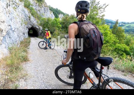 Madre e figlio, turisti in un viaggio in bicicletta nella campagna intorno a Pivka, in bicicletta sulla vecchia strada militare italiana costruita prima della prima guerra mondiale, in slovenia Foto Stock