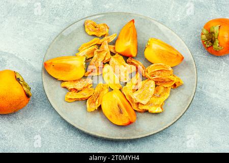 Persimmon secco con persimmon fresco sul tavolo. Frutta esotica essiccata Foto Stock