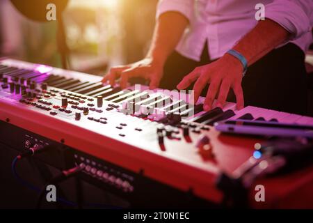 Primo piano: Mani di un pianista o tastierista di una Rock Band che suona un sintetizzatore Foto Stock