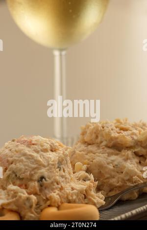 Antipasto con insalata russa con ciambelle di pane accompagnato da un bicchiere di vino bianco Foto Stock