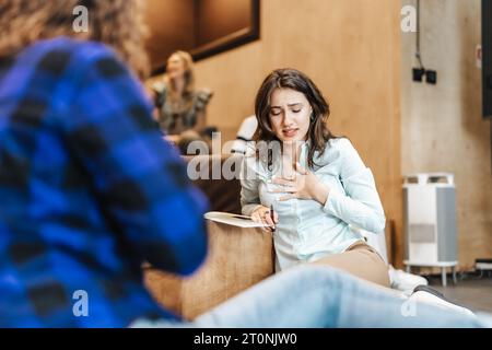 Simpatica dipendente che si scusa con la collega per l'errore che ha commesso durante il progetto. Foto Stock