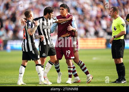 Kieran Trippier del Newcastle United (a sinistra) e Edson Alvarez del West Ham United sono separati mentre l'arbitro Peter Bankes (a destra) guarda durante la partita di Premier League al London Stadium. Data immagine: Domenica 8 ottobre 2023. Foto Stock