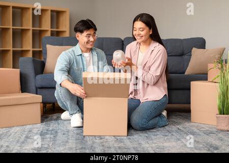 La coppia giapponese confeziona gli effetti personali in scatole preparando il trasferimento di una nuova casa Foto Stock