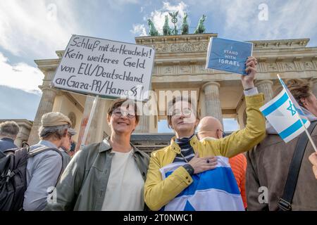 Berlino, Germania. 8 ottobre 2023. L'8 ottobre 2023, durante la protesta di Berlino, Saskia Esken, leader del Partito Socialdemocratico di Germania, si presentò in solidarietà con un manifestante avvolto da una bandiera israeliana. Il manifestante tenne un cartello che proclamava: "Io sono con Israele”. Sullo sfondo dell'iconica porta di Brandeburgo, un altro manifestante è stato avvistato con un cartello che recita: "Fine dell'ipocrisia, niente più denaro dall'UE e dalla Germania a Gaza, Hamas. Crediti: ZUMA Press, Inc./Alamy Live News Foto Stock