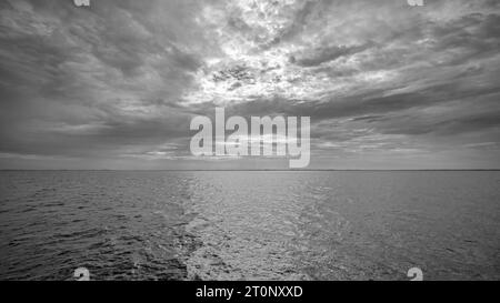 Fotografia grandangolare in bianco e nero dell'Oceano Atlantico con la costa del New Hampshire all'orizzonte. Foto Stock