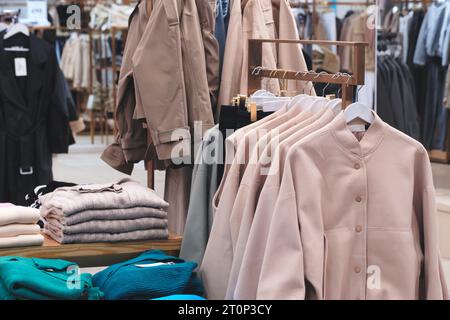 Vestiti e jeans su grucce in un negozio Foto Stock