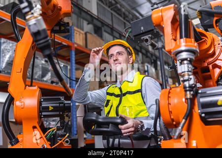 Uomo ingegnere moderno intelligente che utilizza la moderna tecnologia robotica. Configurazione del braccio di saldatura robotizzato nel processo di produzione dell'automazione in fabbrica Foto Stock