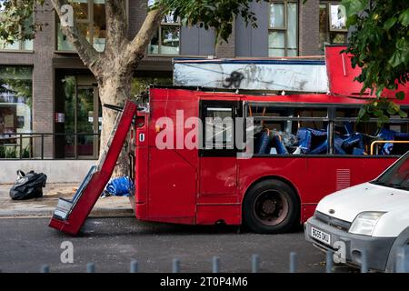 I resti di un autobus utilizzato come prop in un film ambientato a Spa Road, a Bermondsey, nel sud di Londra, durante le riprese degli attentati di Londra del 7 luglio 2005, chiamato anche 7/7, quando un autobus a due piani numero 30 è stato fatto saltare in aria a Tavistock Square. Quattro attentatori suicidi con zaini pieni di esplosivi hanno attaccato il centro di Londra, uccidendo 52 persone e ferendone altre centinaia. Data immagine: Domenica 8 ottobre 2023. Foto Stock