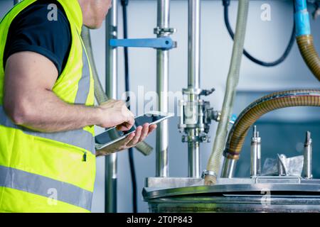 Tecnico ingegnere lavoratore maschio che lavora nella sala caldaia per il controllo della routine di manutenzione del tubo del gas nella fabbrica industriale Foto Stock