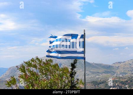 Bandiera nazionale greca in cima alla collina del monastero di Tsambika a Rodi, in Grecia Foto Stock