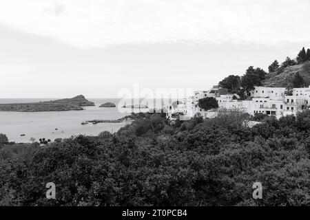 Vista in bianco e nero della città di Lindos, edifici bianchi lungo la St La costa della baia di Paul Foto Stock