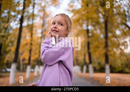 Ritratto di bambina felice nel parco giallo autunnale. Stagione autunnale. Foto Stock