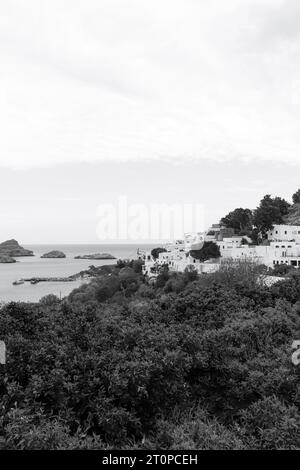 Vista in bianco e nero della città di Lindos, edifici bianchi lungo la St La costa della baia di Paul Foto Stock