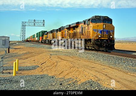 Un treno merci intermodale a doppio stack della Union Pacific è visto passare i binari di Bertram diretti a est sulla Sunset Route vicino alla riva del Mare di Salton. Foto Stock