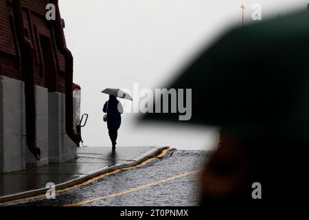 Mosca, Russia. 8 ottobre 2023. La gente cammina nella Piazza Rossa durante la pioggia e il vento a Mosca, in Russia. Crediti: Nikolay Vinokurov/Alamy Live News Foto Stock