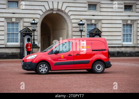 Royal mail Post Office, furgone rosso che arriva a Buckingham Palace Londra, Regno Unito, con guardia in servizio Foto Stock