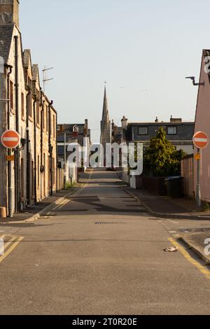 Chiesa di Scozia, Chiesa Parrocchiale di Invergordon con molti edifici residenziali e strada di fronte all'alba, foto verticali Foto Stock