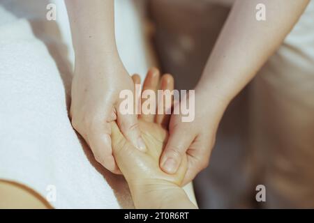 Il tempo dell'assistenza sanitaria. Primo piano sul massaggiatore nella cabina massaggiante mani dei clienti. Foto Stock