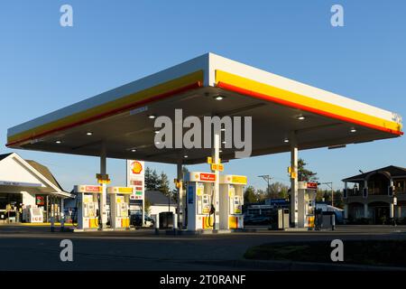 North Bend, WA, USA - 8 ottobre 2023; stazione di servizio Shell con pompe sul piazzale al sole del mattino presto e cielo blu Foto Stock