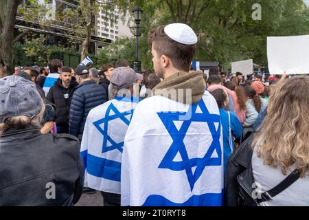 NEW YORK, NEW YORK - 8 OTTOBRE: I partecipanti si esibiscono con bandiere israeliane in una manifestazione pro-Israele fuori dalle Nazioni Unite, mentre il Consiglio di sicurezza si riunisce per discutere il conflitto tra Israele e Hamas l'8 ottobre 2023 a New York. Il 7 ottobre, il gruppo militante palestinese Hamas lanciò un attacco a sorpresa contro Israele da Gaza via terra, via mare e via aerea, uccidendo oltre 700 persone e ferendone più di 2000. Secondo i rapporti, 130 soldati e civili israeliani sono stati rapiti da Hamas e portati a Gaza. Crediti: Ron Adar/Alamy Live News Foto Stock