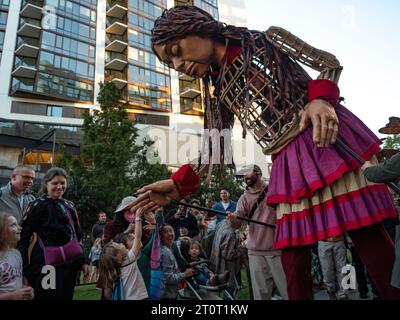 Atlanta, Georgia, USA. 8 ottobre 2023. Il piccolo Amal, un burattino torreggiante di una bambina siriana rifugiata di 10 anni, saluta una giovane sostenitrice. Mentre Amal visita le comunità in tutti gli Stati Uniti, dimostra la resilienza dei rifugiati e il potere delle arti di riunire persone diverse. (Immagine di credito: © sue Dorfman/ZUMA Press Wire) SOLO USO EDITORIALE! Non per USO commerciale! Crediti: ZUMA Press, Inc./Alamy Live News Foto Stock