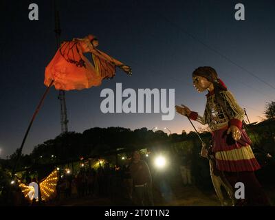 Atlanta, Georgia, USA. 8 ottobre 2023. Il piccolo Amal, un burattino torreggiante di una bambina siriana rifugiata di 10 anni, cerca di toccare la ballerina umana delle farfalle. Mentre Amal visita le comunità in tutti gli Stati Uniti, dimostra la resilienza dei rifugiati e il potere delle arti di riunire persone diverse. (Immagine di credito: © sue Dorfman/ZUMA Press Wire) SOLO USO EDITORIALE! Non per USO commerciale! Crediti: ZUMA Press, Inc./Alamy Live News Foto Stock