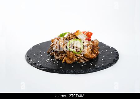 Tagliatelle di grano saraceno con gamberetti in pechina sause su un piatto nero Foto Stock