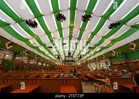 Monaco di Baviera, Germania, UE - 18 settembre 2023. Oktoberfest Munich Beer Tent interno con decorazioni, gente che beve, mangiare in Dirndls e lederhosen. Foto Stock