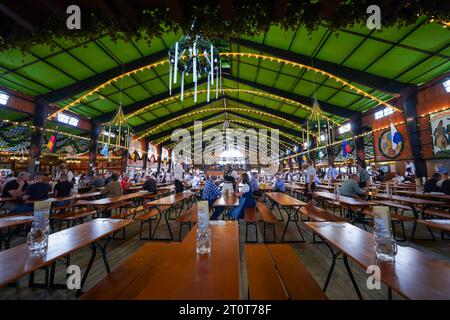 Monaco di Baviera, Germania, UE - 18 settembre 2023. Persone che bevono e mangiano all'interno di una tenda della birra all'Oktoberfest di Monaco, indossando abiti tradizionali. Foto Stock