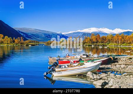 Motoscafi su una spiaggia in un paesaggio montano in autunno Foto Stock