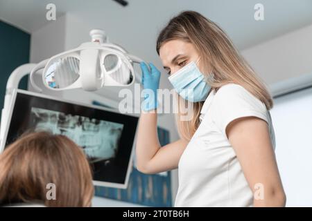 Il paziente ha l'opportunità di migliorare la qualità della sua vita grazie ad un sorriso sano. Il dentista controlla attentamente il processo di trattamento Foto Stock