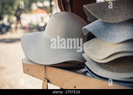 Italia - 7 agosto 2023: Cappelli da sole in una mensola di legno in vendita *** Sonnenhüte in einem Holz Regal zum Verkauf Foto Stock