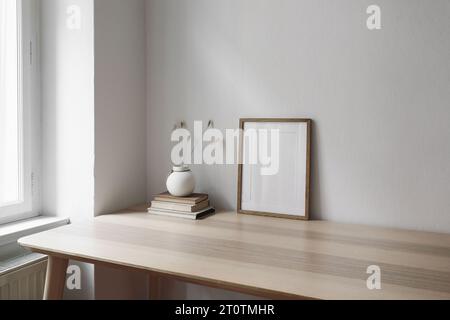 Elegante soggiorno con vista laterale. Mockup verticale con cornice in legno sul tavolo vicino alla finestra. Vaso con coda di coniglio asciutta, erba di Lagurus ovatus e vecchio Foto Stock