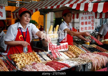 Bancarelle alimentari al mercato alimentare Donganmen, vicino a Wangfuging Dajie, Pechino, Cina. Foto Stock